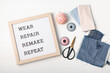 Jeans with letter board and text wear, repair, remake, repeat. Slow fashion, circular economy, eco friendly sustainable shopping, thrifting second hand shop concept.