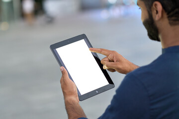Business man professional holding digital tablet in hands using pad with white empty screen mock up template outdoors on urban city street. Mockup display for ads. Over shoulder view