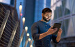© insta_photos - Rich successful eastern indian business man professional entrepreneur standing outdoors on street holding using digital tablet online technology in night big city with urban lights and skyscrapers.