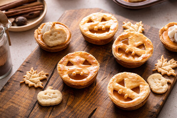 Wall Mural - Halloween pumpkin pies with carved pumpkin face on top