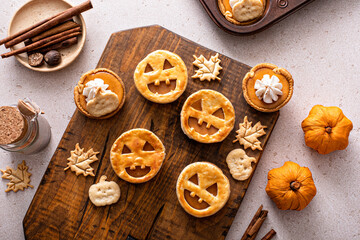 Wall Mural - Halloween pumpkin pies with carved pumpkin face on top