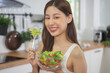 © Pormezz - Smiled happy woman eating a bowl of salad as breakfast for good health.