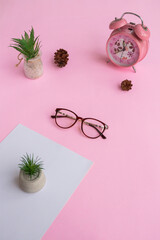 Wall Mural - Cat's eye glasses in the photo from above with a minimalist concept on a purple paper background with an alarm clock decoration and dry leaves