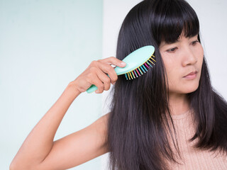 Woman Combing Hair close up isolated on white background,Female Com Hair after shower at Home in Holidays, Authentic Black Hair and Skin Tan Asian Thailand,Lifestyle for Beauty and Good Health concept