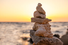 Stones Stacked In A Turret In The Rays Of The Setting Sun. Marine Weathered Limestone
