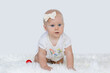 Adorable little baby girl creeping and playing in the home. White background.