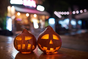 two carved pumpkins during the halloween celebration at night in the city.