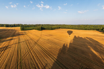 Wall Mural - A trip with a hot air balloon over the field and forest of Latvia. Balloon shadow.