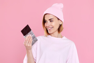 Wall Mural - blonde woman in t-shirt and hat holding chocolate bar