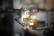 © RoBird - Person using a social media marketing concept on mobile phone with notification icons of like, message, comment and star above smartphone screen.