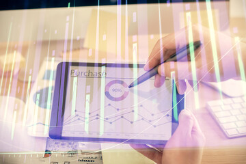 Double exposure of man's hands holding and using a phone and financial chart drawing. Market analysis concept.