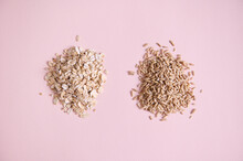 Flat Lay. Heap Of Organic Wholesome Cereals Oatmeal Groats And Oat-flakes Scattered On Pink Background With Copy Space.
