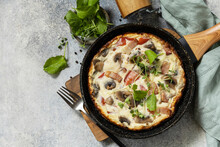 Italian Breakfast Dish. Rustic Omelette (frittata) With Mushrooms And Bacon On A Cast Iron Pan. View From Above. Copy Space.