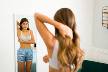 Hispanic Woman Looking In The Mirror And Doing A Self Exploration Breast Exam