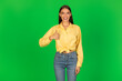 © Prostock-studio - Cheerful Female Gesturing Thumbs Up Standing Over Green Background