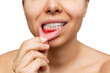 © Марина Демешко - Gum inflammation. Cropped shot of a young woman shows red bleeding gums pulling the lip isolated on a white background. Close up. Dentistry, dental care