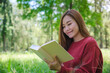 © Farknot Architect - Portrait of a beautiful young asian woman reading a book while sitting in the park