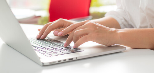 female hands use a laptop in the office.