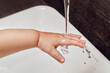 © Андрей Журавлев - Toddler baby hand is washed under running water from the tap in the sink. Child learns to wash his hands