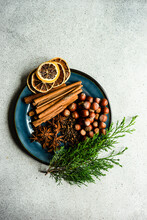 Overhead View Of Cinnamon Sticks, Star Anise, Hazelnuts, Cloves, Dried Orange Slices And Thuja Branches