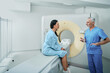 Computed Tomography. Medical professional talking with female patient in hospital radiology department prior to CT scan being performed