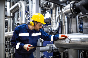 Wall Mural - Petroleum refinery worker standing by pipes and checking production of gasoline.