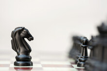 Black Chess Horse Opposite Black Pieces On A Chessboard
