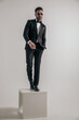 © Viorel Sima - sexy elegant businessman in tux with hand on pocket standing on wooden box