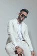 © Viorel Sima - sexy stylish man in white suit with sunglasses posing in a cool way