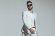 © Viorel Sima - unshaved cool man wearing white stylish suit holding arms in fashion pose