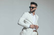 © Viorel Sima - sexy young man in white suit with open collar shirt buttoning jacket