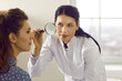 © Studio Romantic - Female doctor looking at patient's skin through magnifying glass. Professional dermatologist and skincare specialist investigating moles or tumor growth signs on woman's face. Skin checkup concept