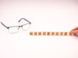 Nauczyciel - napis z drewnianych literek na białym tle, okulary 
