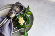 Close-Up Of A Rustic Place Setting On A Table With A White Gardenia Flower
