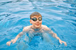 © Andrii IURLOV - Smiling boy portrait in swimming goggles, Child swim in the pool, sunbathes, swimming in hot summer day. Relax, Travel, Holidays, Freedom concept.