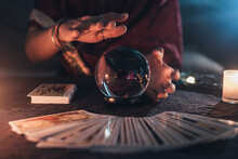 Fortune Teller With Illuminated Crystal Ball And Tarot Cards To Prediction Future. Hands Of Astrologists Reading Future And Destiny. Horoscope And Forecasting Concept.