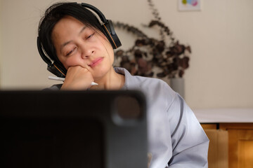 asian woman feel bored when video conference meeting at home