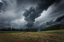 Dramatic Thunderclouds Over A Field With Green Trees