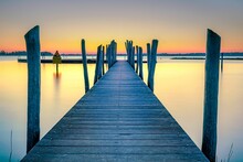 Beautiful Morning At The Lake On A Long Jetty With Wooden Planks And A Colorful Sunrise