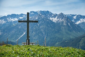 Beautiful view of a wooden cross against a background of snowy mountains and fields