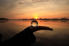Beautiful Golden Sunset Caught In A Glass Ball On Hand.