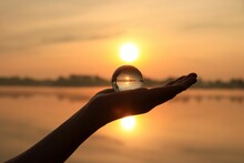 Beautiful Sunset Caught In A Glass Ball In Hand.