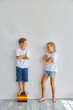 © Inna Vlasova - Cool kids, little boy and girl measure their height a