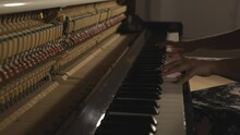 Woman Playing Upright Piano With Open Sound Board Showing Hammers Striking The Strings