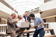 © Westend61 - Cheerful business colleagues celebrating success in corridor