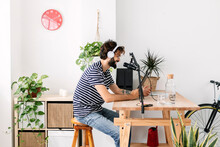 Man Wearing Wireless Headphones Recording Podcast In Home Studio