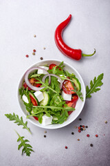 Wall Mural - Healthy vegetarian salad with fresh arugula, cherry tomatoes, soft cheese and cucumbers