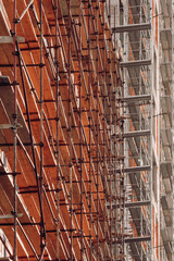 Wall Mural - Scaffolding surrounding a high-rise building, low angle view