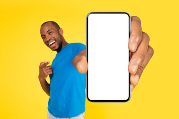 African Man Holding Large Phone Empty Screen Over Yellow Background