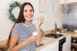 © Xavier Lorenzo - Serene young adult woman having breakfast at home - Smiling millennial female eating natural white bio yogurt in the kitchen - Healthy lifestyle concept